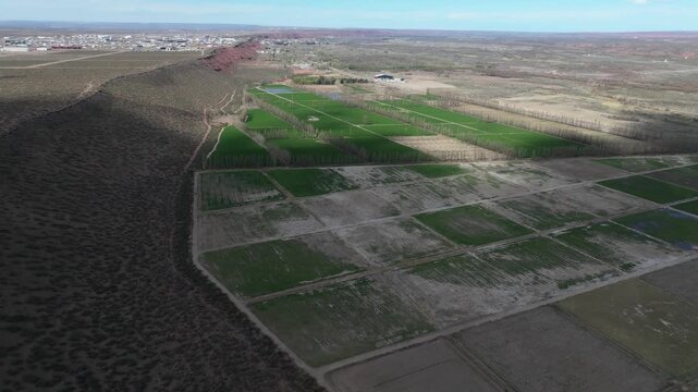 A drone pans across the low-lying green fields of A&ntilde;elo. In the background, the plateau with its oil extraction activity is visible. Far in the distance, the Auca Mahuida volcano can be seen. 4K
