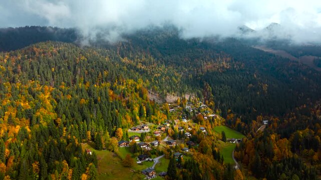 Cinematic aerial of Unken mountain village, Heutal, Austria. Rustic houses, meadows and vivid autumn foliage.