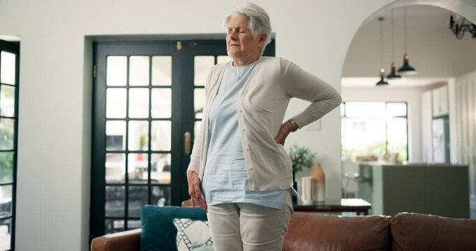 Back pain, tired and osteoporosis with old woman on sofa for accident, inflammation and injury. Fibromyalgia, emergency and spine strain with senior person in living room of home for medical crisis