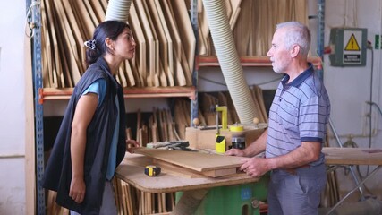 Experienced carpenter teaching a young apprentice woodworking