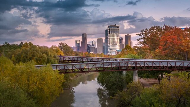Timelapse of Houston downtown skyline at sunset as clouds move and business city light turn on, modern skyscrapers, urban traffic, and day to night in of Houston downtown, Texas, United States USA