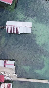Vertical aerial birds-eye view showcasing rooftops and waterfront structures on Bastimentos Island in Bocas del Toro District, Panama.