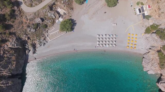 Top-down drone shot of Achata Beach in Karpathos, revealing turquoise waters, sandy shoreline, and the natural beauty of the cove.