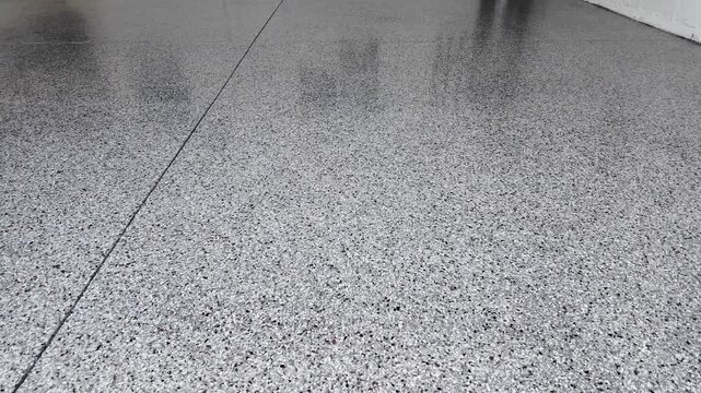 freshly coated garage, not with epoxy, but with a polyaspartic topcoat to make a garage floor look like a showroom