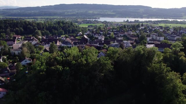 Revealing a green city with a lake on a sunny day, Uster, Switzerland