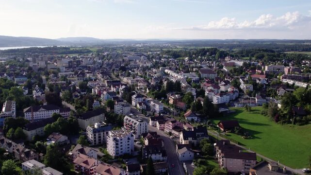 Flying over a quiet green city with a lake, Uster, Switzerland