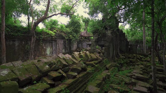 Overgrown stone corridors of Beng Mealea temple hidden in dense jungle, broken stone rocks, medium