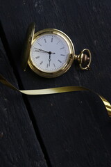 New Year`s Eve Concept. Gold pocket watch оn vintage background. .