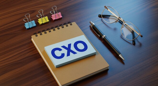 CXO concept on office desk with pen, glasses, binder clips and notebook represents executive leadership