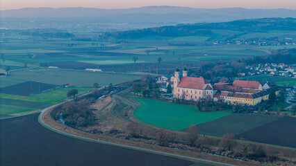 Weite Landschaft mit einem Dorf und einer Kirche in der Dämmerung © Joachim