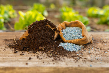Bio organic and synthetic fertilizer products on wooden board in farm
