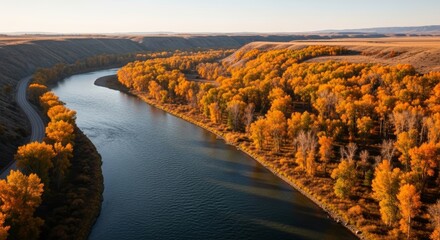 River winding through autumn forest with road