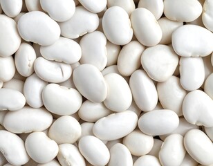 Overhead shot of a pile of lima beans, smooth, white, and tightly packed together, filling the entire frame