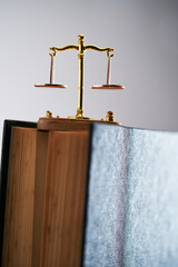 small libra scale on top of hard cover law book