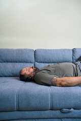 Man rests on couch with headphones