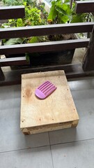 Purple Plastic Comb on Wooden Box on Balcony