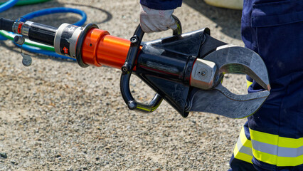 Fototapeta premium A firefighter with a large hydraulic cutting tool known as The Jaws Of Life