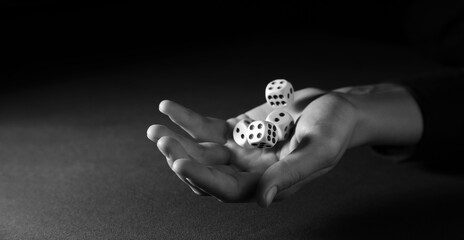 Male hand with game dices on black background