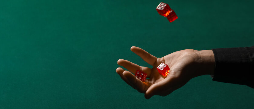 Hand with game dices on green background with space for text