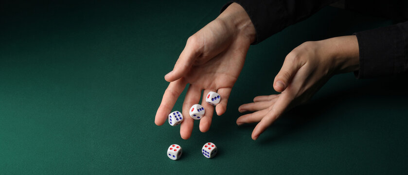 Hands throwing game dices on green background with space for text