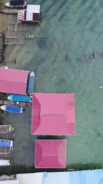Vertical establishing drone view highlighting Bastimentos Island&rsquo;s coastal structures, boats, and tropical surroundings.