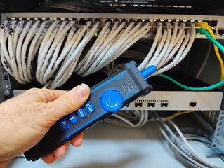 Technician Using a Digital Network Cable Tracker Probe to Identify and Test Ethernet Connections in...