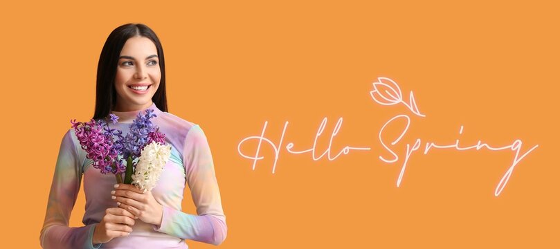 Beautiful young woman with hyacinth flowers and text HELLO, SPRING on orange background