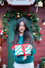 During Christmas time, a happy young woman enjoys a large Christmas gift.