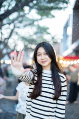  A young woman wearing a scarf and gloves is smiling outdoors in the snow during the winter.