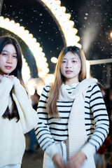  A young woman wearing a scarf and gloves is smiling outdoors in the snow during the winter.