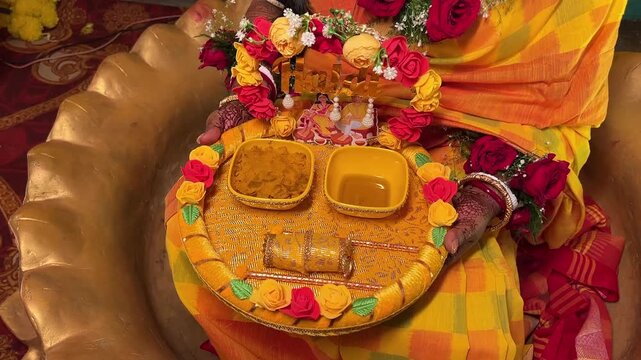 An Indian bride holding haldi gift hamper in a Bengali wedding in India 