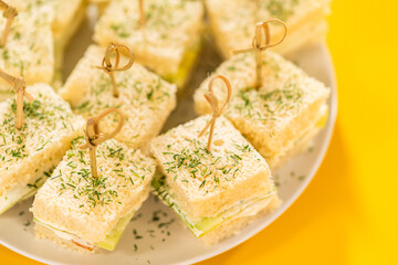 Mini Cucumber Tea Sandwiches on Yellow Background
