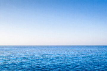Obraz premium Horizontal minimalist seascape photo of a calm blue ocean meeting a clear sky at the horizon. Clean lines, natural light, and soft gradients create a peaceful and expansive mood