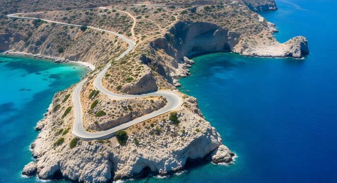 Aerial view of serpentine coastal road leading to a secluded turquoise bay on Karpathos island, Greece