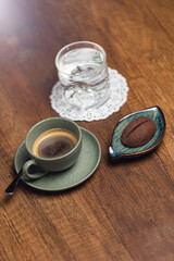 Elegant Espresso Cup With Water Glass And Chocolate Cookie On Warm Wooden Table