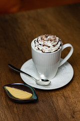 Whipped Cream Coffee Latte in White Mug With Chocolate Drizzle and Shavings, Fresh Cookie Side
