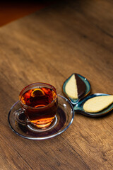 Cozy Tea Time With Amber Tea In Glass Cup And Ceramic Leaf Plates On Wooden Table