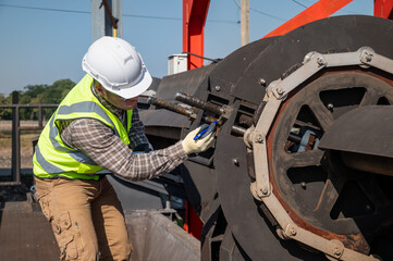 Professional Engineer Checking Machinery Condition at Industrial Worksite