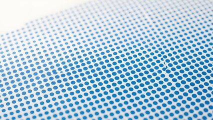 Close-up of a light blue perforated surface with a uniform grid of small, circular holes, creating a clean, modern, and technical texture for design backgrounds.


