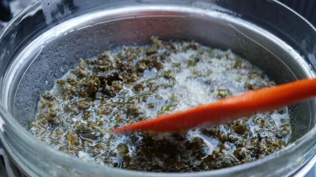 Boiling Cannabis in Butter Double Boiler: Marijuana Infusion Cooking Process Bubbles Steam Cannabutter Making Method