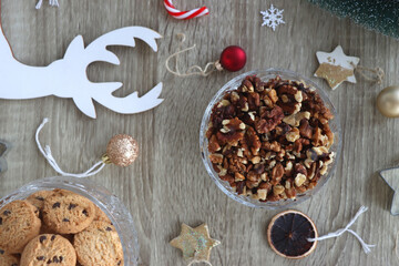 Various Christmas decorations, cookies, chocolate and nuts on wooden background. Flat lay.