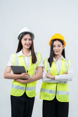 Vertical photo of two Asian women engineers analyzing construction analytics, highlighting AI data processing, smart project monitoring, teamwork synergy, and modern safety awareness.