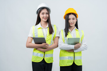 Vertical photo capturing Asian female engineers collaborating on digital tools, representing AI innovation, smart construction coordination, efficient teamwork, and future-ready industry standards.
