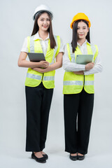 Vertical photo of Asian female engineers reviewing project dashboards, showcasing AI-powered analytics, smart construction management, teamwork efficiency, and safety-focused workplaces.