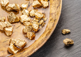 Gold nuggets on brass plate top view. Imitation of gold nuggets.