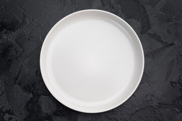 Minimal empty plate on dark background with texture. Modern ceramic tableware mockup with copy space
