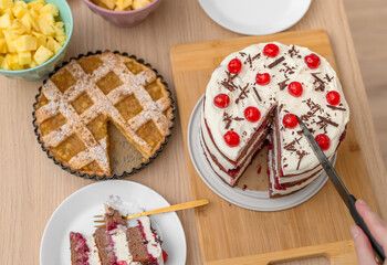 Party table for a party with sweet cakes, sliced ​​cake, fruit, tart