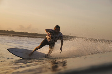 Surfer Carving Low Spray Illuminated Close Foreground Perspective