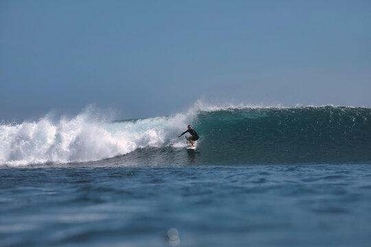 Surfer Navigating Deep Barreling Wave