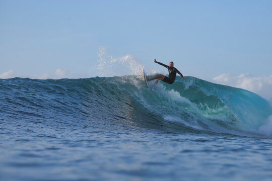 Surfer Crouching Inside Turquoise Ocean Barrel
